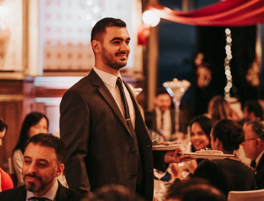 A person stood up and smiling in a restaurant